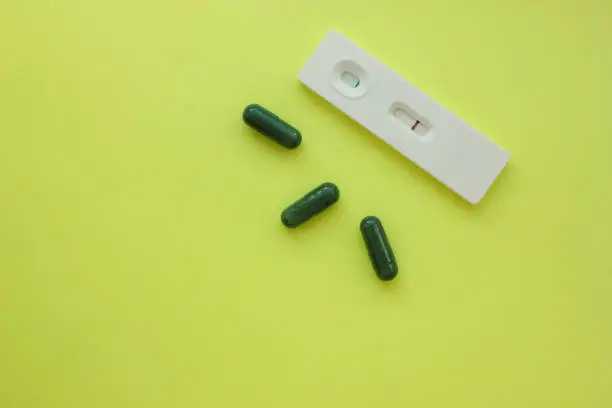 Negative pregnancy test and pills on a yellow background. Motherhood, children, pregnancy, concept of birth control. Health problems and problems with conception. abortion. contraception. Copy space
