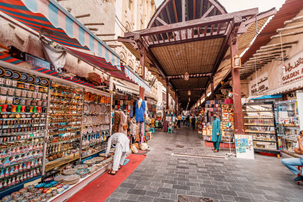old bur dubai souk mercado en el distrito de creek. vendedores y comerciantes con bienes, textiles y recuerdos - golden daisy fotografías e imágenes de stock