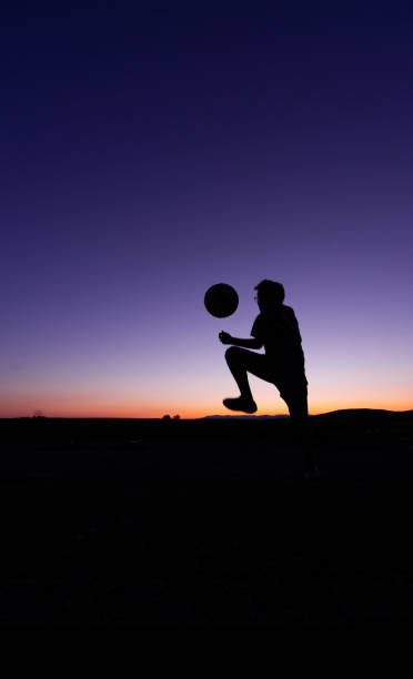 istock Silhouette of a boy with a ball 1332997369