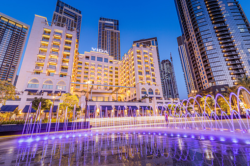 24 February 2021, Dubai, UAE: Vida hotel and illuminated fountain panoramic view in Dubai Marina Creek Harbour
