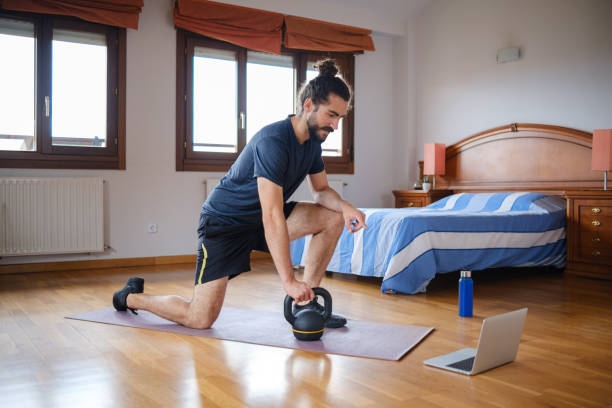 istock Bearded man interacting with an online class on laptop while training at home. 1333001212