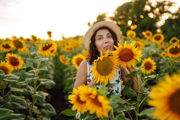 istock Beautiful woman strolling through field with sunflowers at sunset. 1333003708