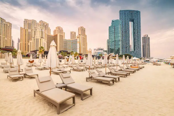 Empty deckchairs with umbrellas and sunbeds at the JBR beach in Dubai. Travel and vacation destinations in United Arab Emirates