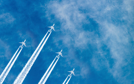 Airplanes flying in parallel in the blue sky.