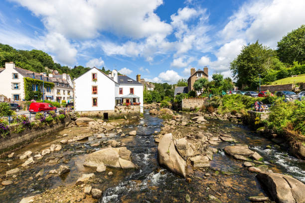 View of the river at low tide running through the romantic village Pont-Aven, a famous tourist resort in Brittany, France.Logo’s and recognizeable people have been blurred.