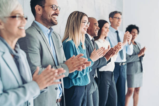 istock Group of business persons standing in a row and applauding 1333016252