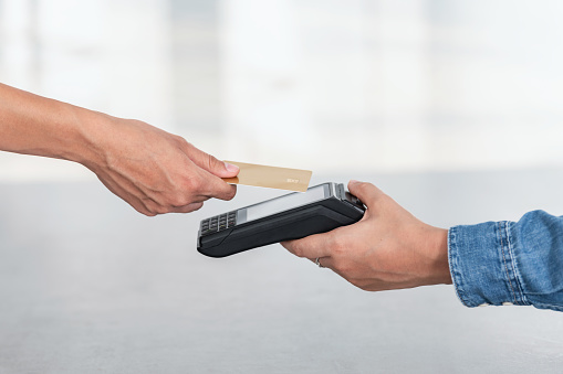 Side view of credit card contactless payment on a illuminated white background