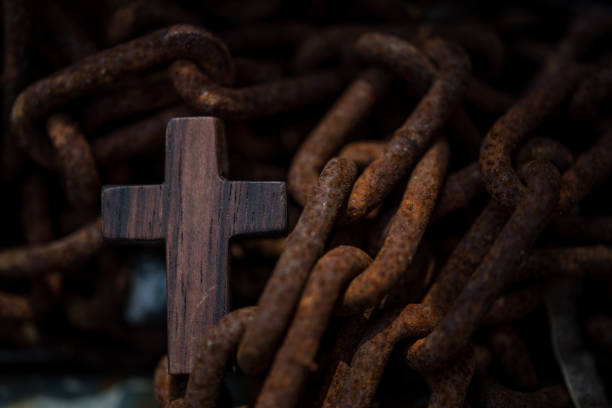 Golden 3D Christian cross on a chain hanging in the dark