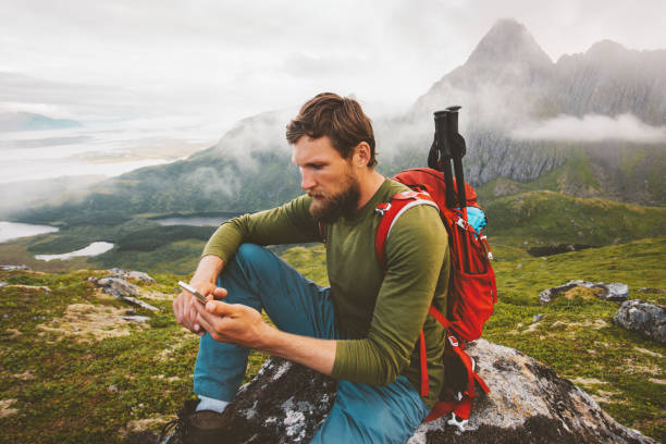 istock Man hiker using smartphone application navigation in mountains travel blogger influencer lifestyle hiking adventure summer trip outdoor backpacking in Norway 1333018817
