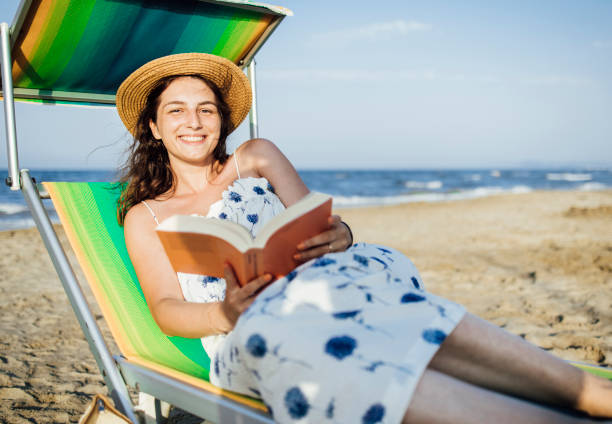 istock Woman sunbathing on the beach with book 1333020659