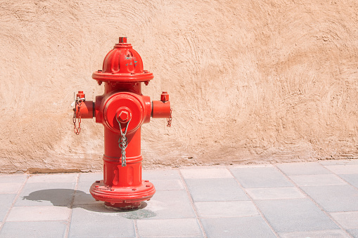 Red water fire hydrant on a pavement of city street. Firefighting and design concept