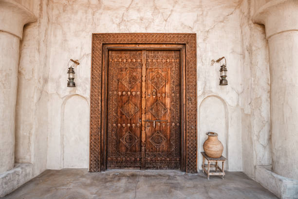 antique wooden door with architectural arch in an ancient sandstone house in bur dubai near creek area - ancient arabic style arch architecture imagens e fotografias de stock