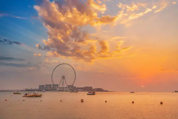 Photo of Red sunset over Bluewaters Island with the famous Dubai Eye Ferris wheel. Panoramic view of the city and nature in UAE