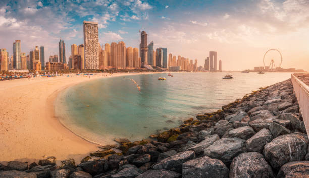 panoramablick auf den goldenen sand, der von der untergehenden sonne im jbr-strandbereich beleuchtet wird. erstaunliche wolkenkratzer und warmes wasser des persischen golfs warten auf gäste und touristen - dubai beach hotel skyline stock-fotos und bilder