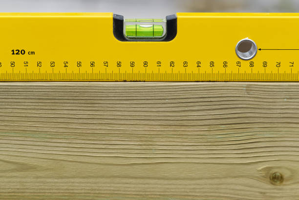 黄色の精神レベルは、木製のボード上の水平に水平に水平に水平。木製の梁の建設作業員ツール測定ツール。 - home improvement carpentry construction work tool ストックフォトと画像