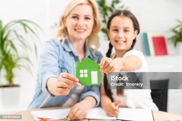 People Charity Family And Home Concept Close Up Of Woman And Girl Holding Green Paper House Cutout In Cupped Hands Stock Photo - Download Image Now