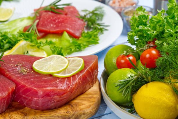 rohes thunfischfiletsteak mit dill, zitrone und gewürzen in olivenschneidebrett - tuna raw portion prepared fish stock-fotos und bilder