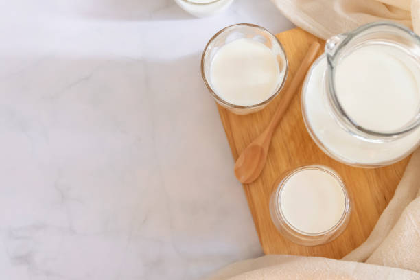 milk drinks in clear jars and glass of milk on wooden board. healthy drink concept. - dairy farm liquid food and drink splashing imagens e fotografias de stock