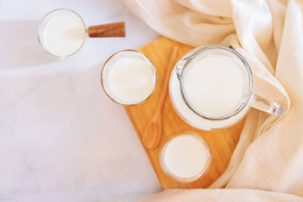 milk drinks in clear jars and glass of milk on wooden board. healthy drink concept. - dairy farm liquid food and drink splashing imagens e fotografias de stock