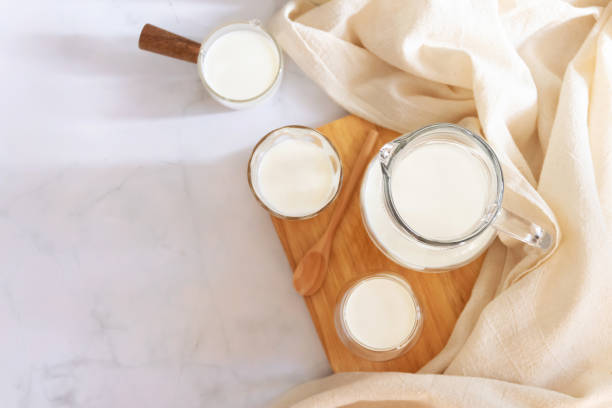 milk drinks in clear jars and glass of milk on wooden board. healthy drink concept. - dairy farm liquid food and drink splashing imagens e fotografias de stock