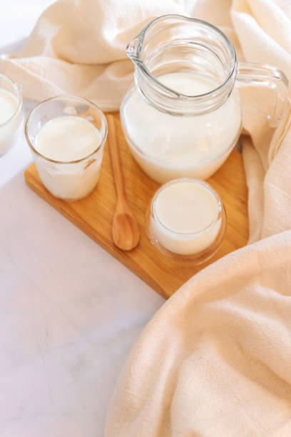milk drinks in clear jars and glass of milk on wooden board. healthy drink concept. - dairy farm liquid food and drink splashing imagens e fotografias de stock