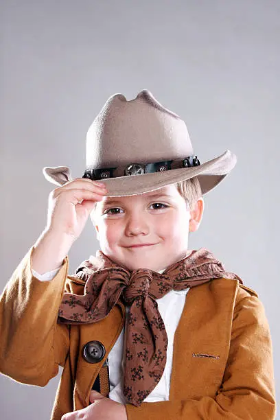 Photo of young cowboy child tipping his hat Howdy