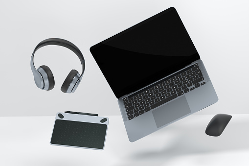 Realistic aluminum laptop with graphic tablet, mouse and headphones on white