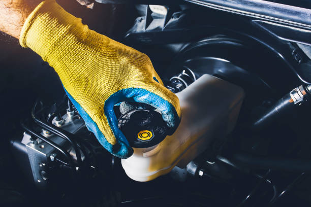 Mechanic is open or close the car's brake fluid reservoir cap The mechanic is open or close the car's brake fluid reservoir cap to check the brake fluid level brake stock pictures, royalty-free photos & images
