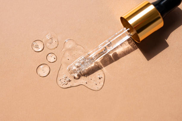 Serum drops and a pipette on a beige background. Top view. Serum drops and a pipette on a beige background. Top view. serum sample stock pictures, royalty-free photos & images