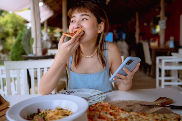 istock Hungry woman playing social media while eating pizza. 1333061273
