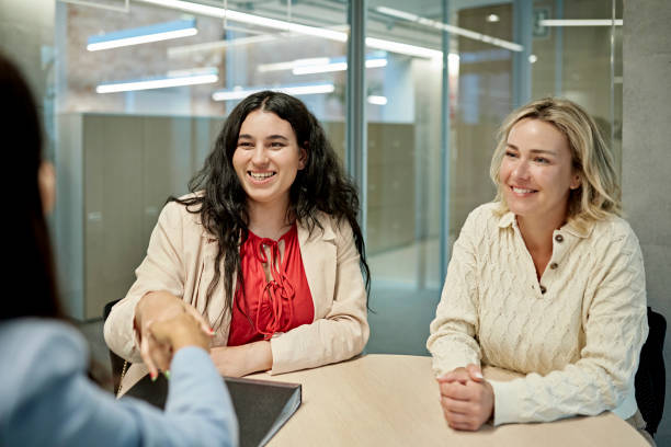 istock Happy Female Clients Shaking Hands with Real Estate Agent 1333062121