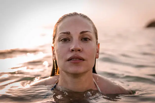 Young woman in water looking at camera. Copy space.