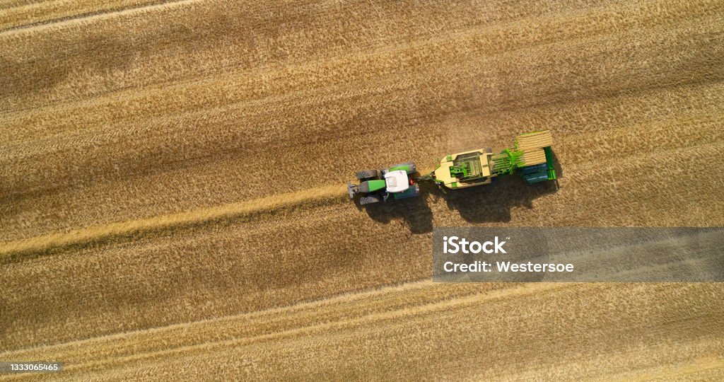 Straw balers from drone point of view Directly above tractor with straw baler. Summer and harvest time. Farmer  saving straw for animals and energy. Aerial View Stock Photo