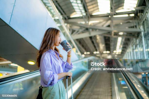 Asian Woman Is Taking The Escalator To Get A Taxi Stock Photo - Download Image Now - Coffee - Drink, One Woman Only, Women