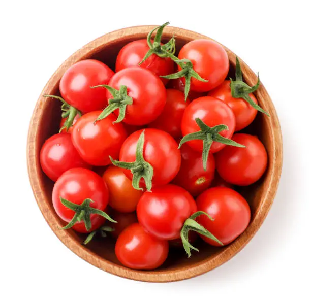 Photo of Cherry tomatoes in a plate on a white background, isolated. Top view