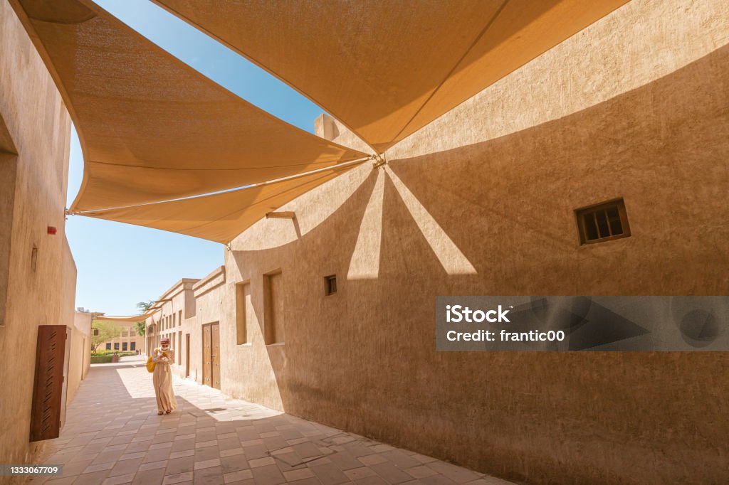 A narrow street in the Bur Dubai and Creek area with canvas curtains to create shade Dubai Stock Photo