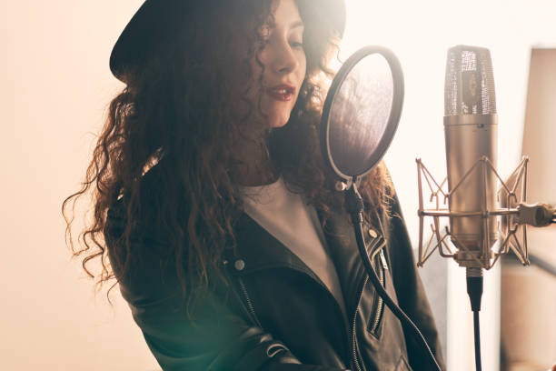istock Pretty female singer recording in music studio 1333069229