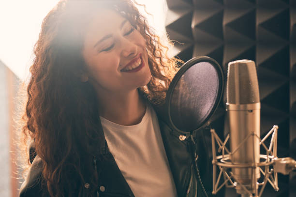 istock Pretty female singer recording in music studio 1333069233