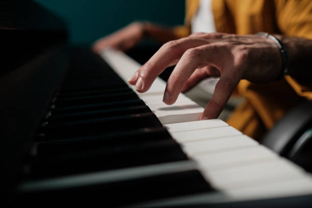 Male hands playing keyboard at the studio