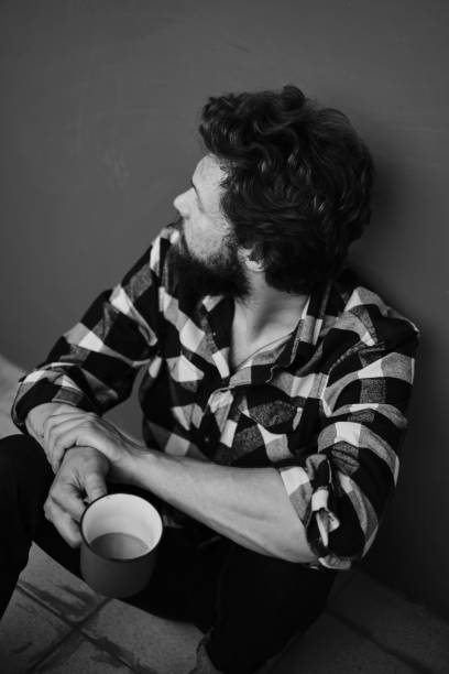 istock Man sitting on the floor and drinking tea 1333069988