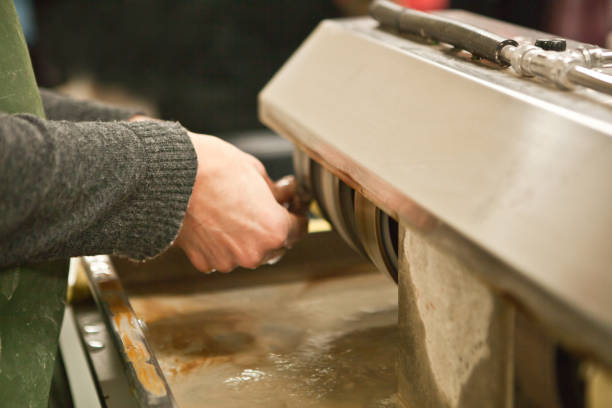istock worker polishing boulder precious stone. worker hands, no face, unrecognizable person. worker cutting a stone 1333073648