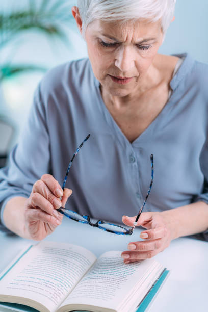 istock Senior Woman a Reading Book. Vision Loss Problems. 1333076617