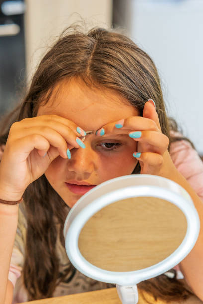 istock Thirteen year old girl close up having eyebrows plucked 1333078740