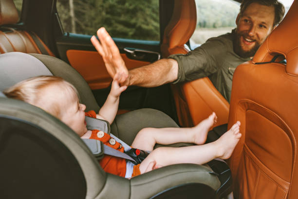 Father with child in car on road trip high five hands baby sitting in safety seat man driver family vacation travel lifestyle happy positive emotions fun Father with child in car on road trip high five hands baby sitting in safety seat man driver family vacation travel lifestyle happy positive emotions fun carsharing photos stock pictures, royalty-free photos & images