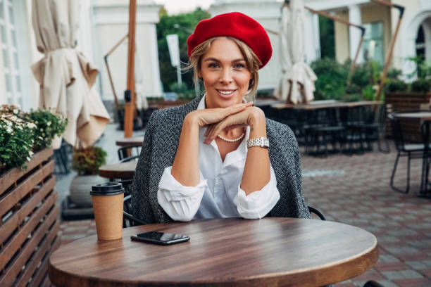 Beautiful woman wearing red beret drinking coffee