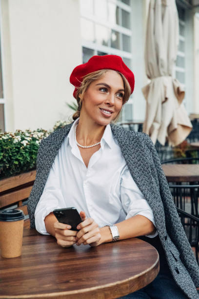 istock Beautiful woman wearing red beret drinking coffee 1333079609
