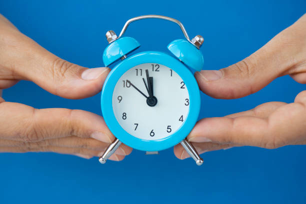 Woman holding alarm clock.
