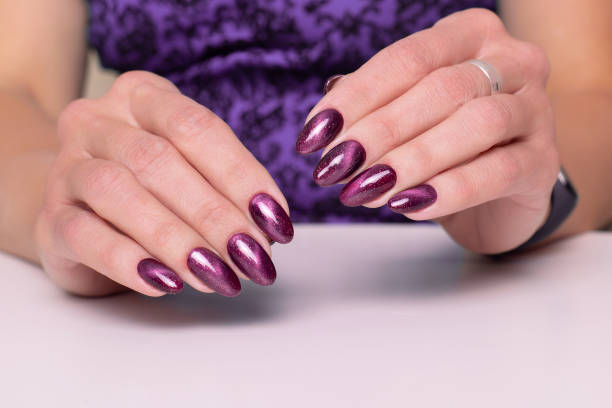 istock Female hand with maroon manicure nails 1333082733