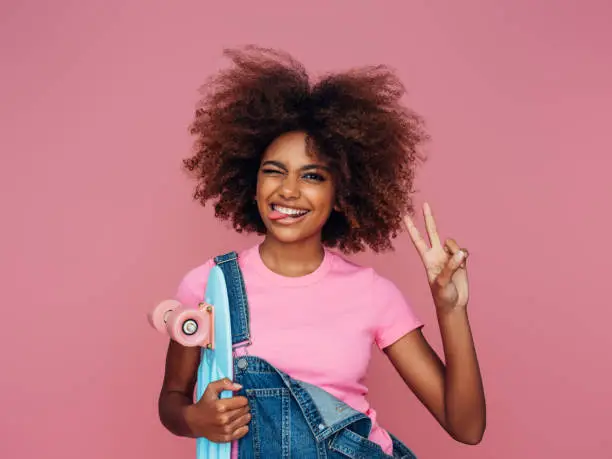 Photo of Photo of young curly girl with skateboard