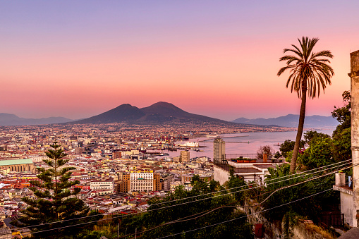 Napoli, Italy - July 11, 2021: Bay of Napoli and Vesuvius volcano in background at sunset in a summer day in Italy, Campania